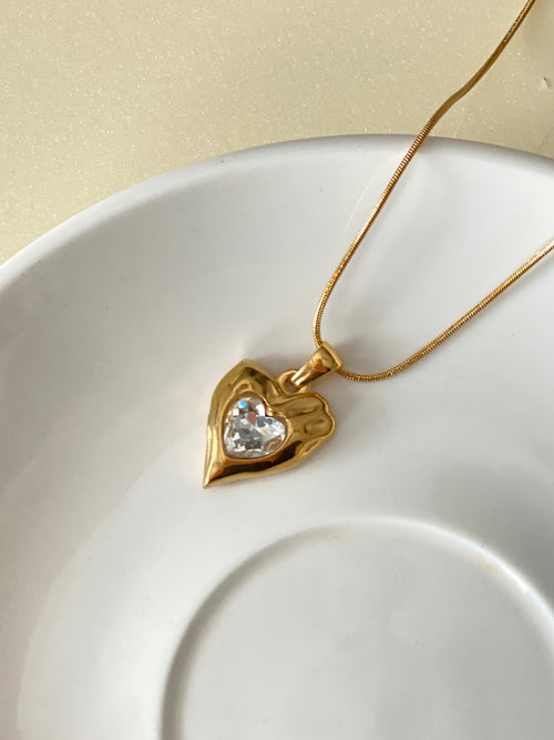 Heart Stone gold heart pendant necklace on white ceramic plate by The Adorn Pakistan