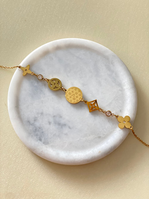 Golden Hour dainty gold coin charm bracelet on marble plate by The Adorn Pakistan