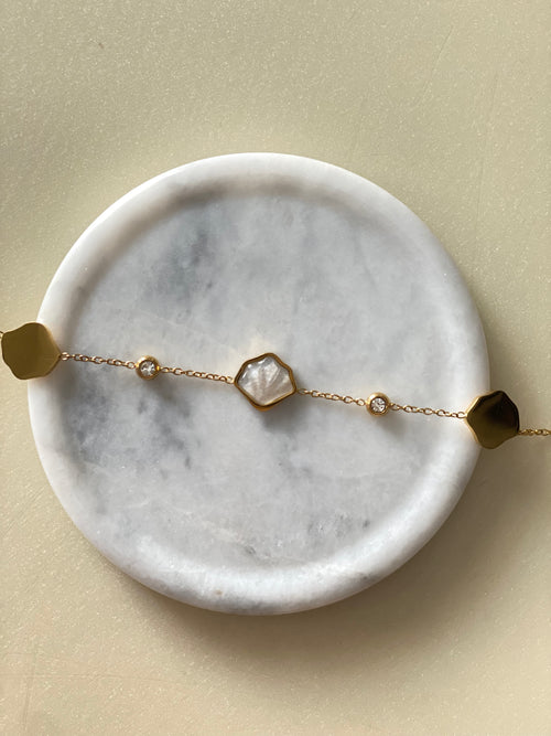 Dainty seashell gold bracelet on marble plate by The Adorn Pakistan